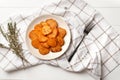 Plate with deliciously cooked sweet potatoes, rosemary, sauce and spices, herbs on a wooden Royalty Free Stock Photo