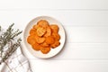 Plate with deliciously cooked sweet potatoes, rosemary, sauce and spices, herbs on a wooden Royalty Free Stock Photo