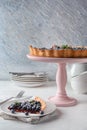 Plate and dessert stand with delicious blueberry pie on table Royalty Free Stock Photo