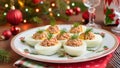 Christmas deviled eggs stuffed with tuna and garnished with fresh dill, served on a festive plate with holly pattern. Holiday Royalty Free Stock Photo