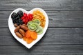 Plate of different dried fruits on wooden background, top view with space for text Royalty Free Stock Photo