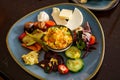 Plate with different food on a wooden table. Top view of the restaurant table with an assortment of meat side dishes