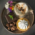 A plate with sweets,coffee and flowers.
