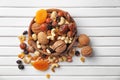 Plate with different nuts and dried fruits on wooden table, top view Royalty Free Stock Photo