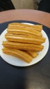 plate with a dozen churros with sugar