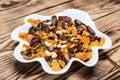 Plate of dried fruits on wooden table, Mix of nuts and berries: raisins, hazelnut, cashews, almonds, yellow, cranberries, dried