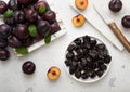 Plate with dried sweet prunes with ripe plums in wooden box on light kitchen background.Top view Royalty Free Stock Photo