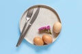 Plate, eggs,flower, fork and knife over light blue background Royalty Free Stock Photo