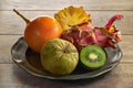 A plate of exotic fruits - Cherimoya, kiwi, pitahaya, granadilla, pineapple