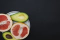 Plate with exotic fruits standing on totaly black table,top view,copy space