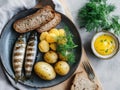 A plate featuring grilled fish, potatoes, and a sauce, garnished with herbs and bread Royalty Free Stock Photo