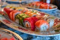 A plate filled with colorful sushi rolls neatly arranged on a table, A plate of colorful sushi rolls arranged tastefully