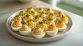 A plate filled with delicious deviled eggs, showcasing their creamy filling and garnished presentation. The eggs are halved and