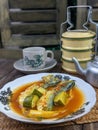 a plate of fish cookes in spicy sour sauce called asam pedas