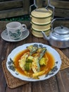 a plate of fish cookes in spicy sour sauce called asam pedas