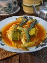 a plate of fish cookes in spicy sour sauce called asam pedas