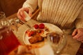 a plate of fish, potatoes and pickled vegetables and hands with a knife and fork Royalty Free Stock Photo