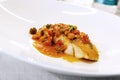 Plate with fish steak stewed with tomato, capers and olives Royalty Free Stock Photo