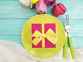 Plate, flower tulip, gift box season celebration on a blue wooden background