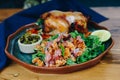 A plate of food with a chicken and rice dish and a salad