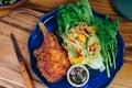 A plate of food with a piece of meat and a salad