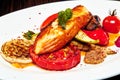 A plate of food with a salmon steak with vegetables