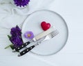 Plate, fork, knife, heart, chrysanthemum flower on white wooden background Royalty Free Stock Photo