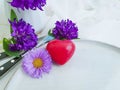 Plate, fork, knife, heart, romance chrysanthemum flower on white wooden background Royalty Free Stock Photo
