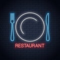 Plate with fork and knife neon sign. Restaurant neon logo on wall background Royalty Free Stock Photo