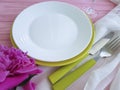 plate, fork, peony flower knife dining design on a pink wooden background Royalty Free Stock Photo