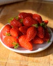 Plate with french red ripe sweet strawberries Fraises de Plougastel, harvested in France