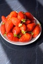 Plate with french red ripe sweet strawberries Fraises de Plougastel, harvested in France