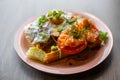 Plate of fresh appetizing bruschetta and omelette with savory tomato and greens on table background closeup. Serving of