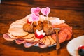 Plate of a fresh assortment of meat on the wooden dinner table