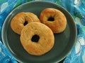 Plate of fresh baked Italian anise seed donuts on blue and green tablecloth with retro design