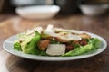 Plate with fresh caesar salad with chicken on old wooden table Royalty Free Stock Photo