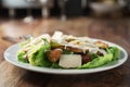 Plate with fresh caesar salad with chicken on old wooden table Royalty Free Stock Photo