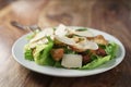 Plate with fresh caesar salad with chicken on old wooden table Royalty Free Stock Photo