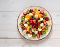 A plate of fresh fruit salad on a wooden table. Kiwi, oranges, blueberries, bananas. Healthy meal. vegetarian dish Royalty Free Stock Photo