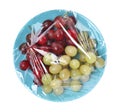 Plate of fresh grapes wrapped with transparent plastic stretch film isolated on white, top view