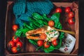 A plate with fresh green raw spinach and fried wild salmon, tomatoes and cream cheese sauce Royalty Free Stock Photo