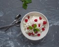 A plate of fresh home-made cottage cheese with sour cream from melted cream of dried cherries and mint leaves. Teaspoons lie side Royalty Free Stock Photo