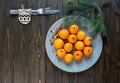 A plate with fresh mandarines stays on the brown table. New Year Royalty Free Stock Photo