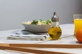 Plate of fresh Mediterranean salad with olive oil served with orange juice on a white wooden table Royalty Free Stock Photo