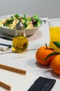 Plate of fresh Mediterranean salad with olive oil served with orange juice on a white wooden table Royalty Free Stock Photo