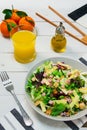 Plate of fresh Mediterranean salad with olive oil served with orange juice on a white wooden table Royalty Free Stock Photo