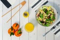 Plate of fresh Mediterranean salad with olive oil served with orange juice on a white wooden table Royalty Free Stock Photo