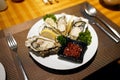 A plate of Fresh opened oyster with lemon, served with mignonette sauce, Seafood buffet line in Restaurant, Delicious