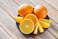 Plate with fresh oranges on wooden table Royalty Free Stock Photo