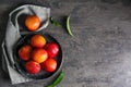 Plate with fresh peaches on dark table